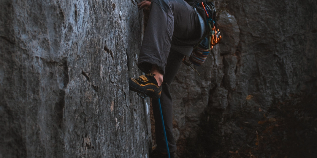 Climber standing on small foot hold